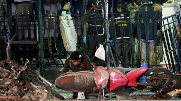 Experts investigate the remains of destroyed motorcycles at the Erawan shrine.