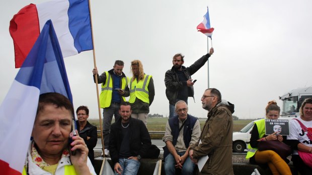 Demonstrators hold French flags as truckers block the highway near Calais on Monday.