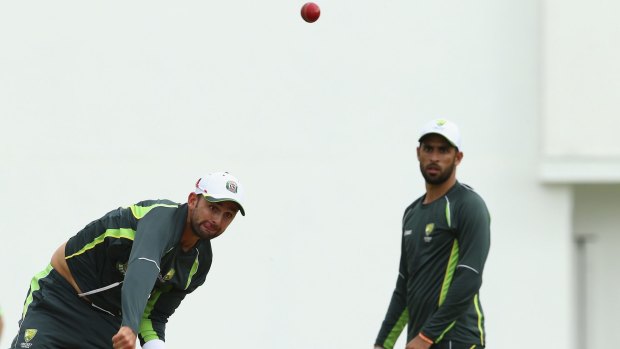 Spin aces: Nathan Lyon bowls as Fawad Ahmed looks on during an Australian nets session at Windsor Park in Roseau, Dominica.
