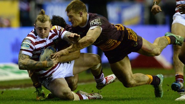 Covered: Josh Charnley of the Wigan Warriors is tackled by Brisbane's Aaron Whitchurch in their World Club Series clash.