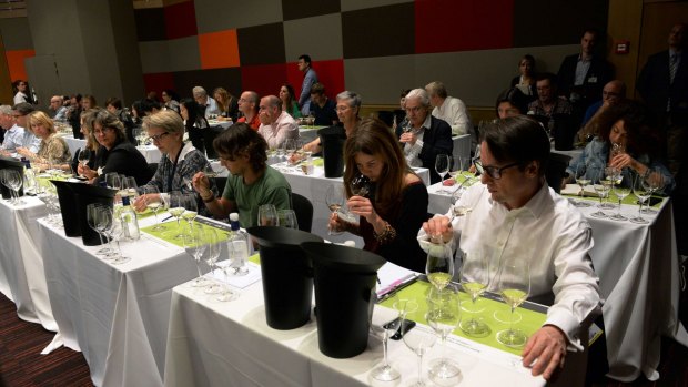 People sample the bouquet of a glass of wine during a workshop Vinexpo last week.