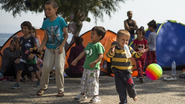 Migrant boys play with a ball at a beach near the port at the south-eastern Greek island of Kos on Sunday.