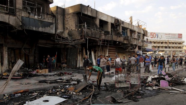 People gather at the site of car bomb in New Baghdad, which killed at least 20 people and injured 48 in a Shiite district.