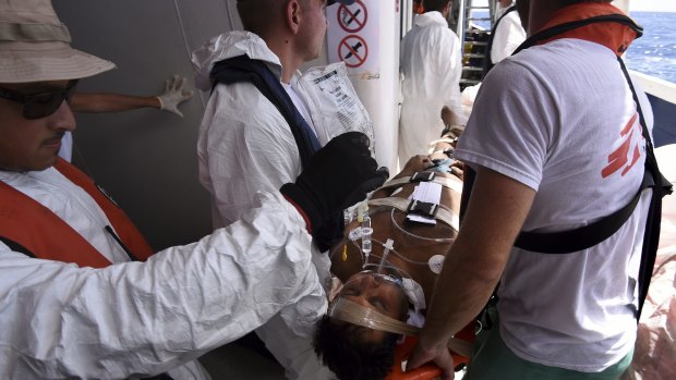 An unconscious refugee is evacuated from the MY Phoenix by MSF and Migrant Offshore Aid Station crew to an Italian warship. 