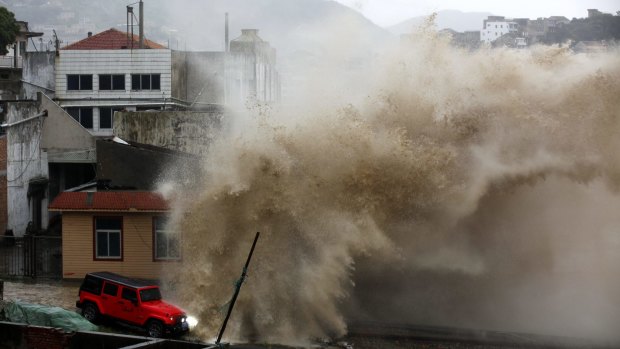 A strong wave breaks over a vehicle along the shore ahead of the landfall of Typhoon Chan-Hom in Wenling in eastern China's Zhejiang province on Friday.