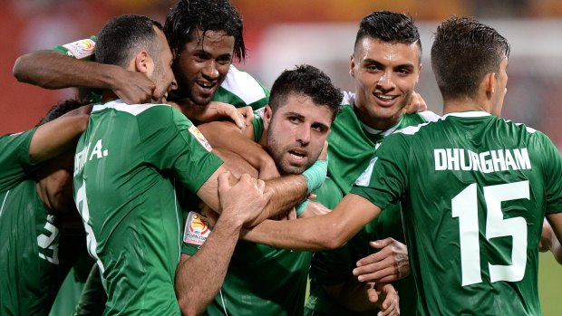 Iraq's Yaser Kasim is mobbed by his teammates after scoring what turned out to be the lone goal of the match.