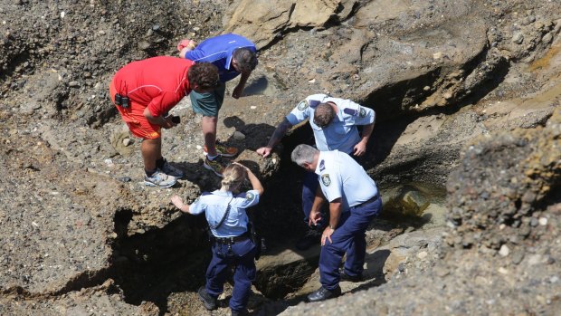 Police look into the crevice at Snapper Point, where Jesse Howes disappeared.