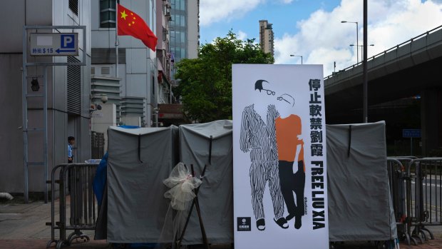 A banner displaying a sketch of late Chinese Nobel Peace laureate Liu Xiaobo and his wife Liu Xia is displayed outside the Chinese liaison office in Hong Kong.