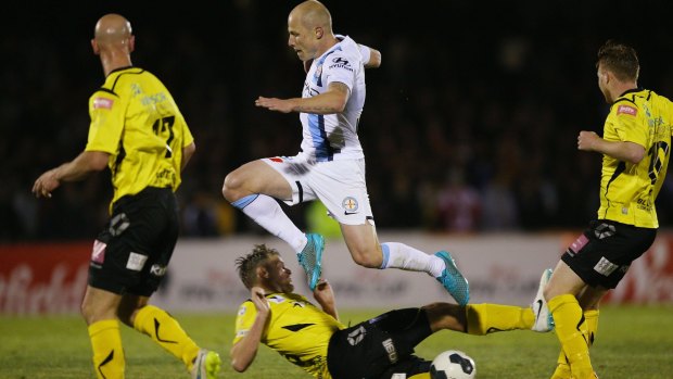 Three strikes: Aaron Mooy of Melbourne City leaps over Jack Petrie of Heidelberg United during the FFA Cup quarter-final on Tuesday.