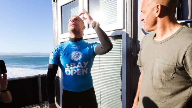 Mick Fanning looks to the skies in thanks after explaining to Kelly Slater (right) what he went through. 