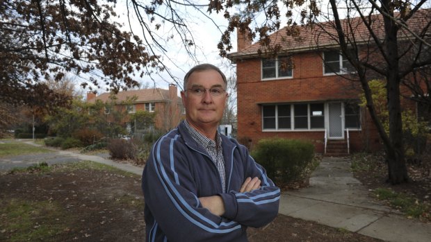 John Keeley in front of two government-owned duplexes in Boolimba Crescent, Narrabundah, which are to be demolished to make way for nine public housing units.