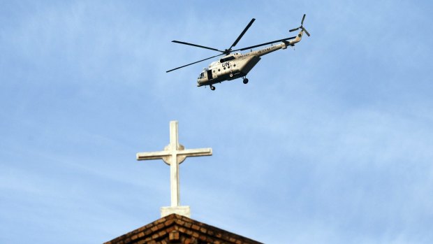 A UN peacekeeping helicopter flies over Bangui's cathedral, Central African Republic, on Sunday. 