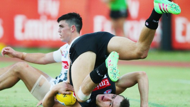 Darcy Moore takes a tumble but ensures that he has ball in hand.