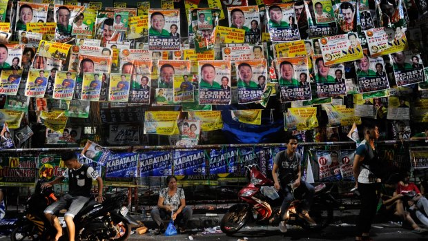 People wait for results in polling centres after voting ended in Manila on Monday.