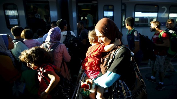 Travellers believed to be migrants coming from Hungary enter a train to Germany at the railway station in Vienna on Monday.