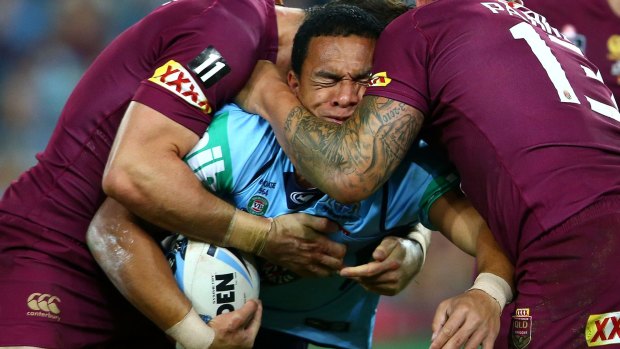 Crunched: Blues winger Will Hopoate is squeezed by the Queensland defence.