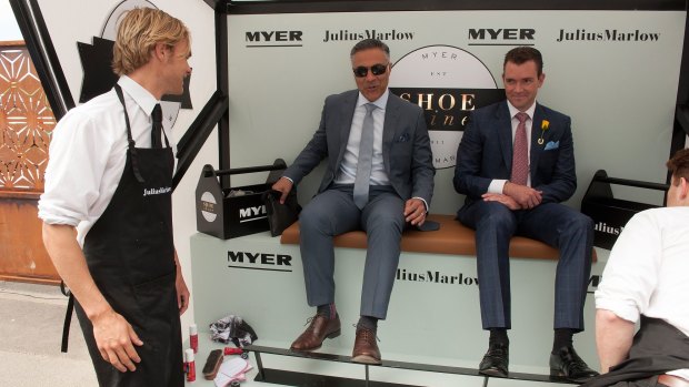 Ahmed Fahour (left), taking advantage of a free shoe shine at the 2015 Melbourne Cup.  