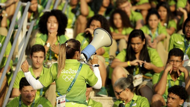 Olympic Park workers listen to instructions before the start of the Rio 2016 Summer Olympics.