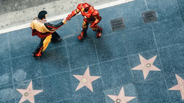 Elvis Presley and Ironman impersonators greeting each other on the Hollywood Walk of Fame. 

