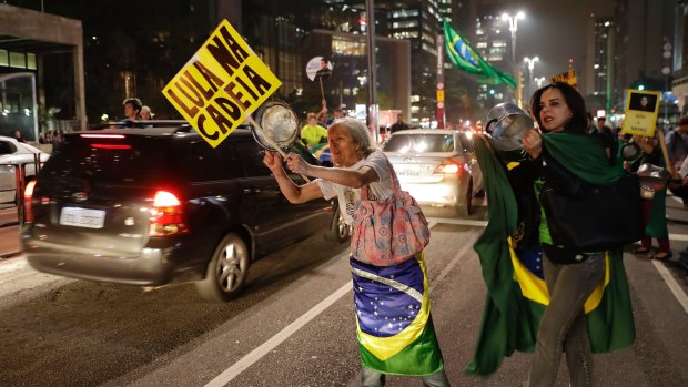Other demonstrators hold signs that read "Lula in Jail" as they celebrate the decision in Sao Paulo on Wednesday.