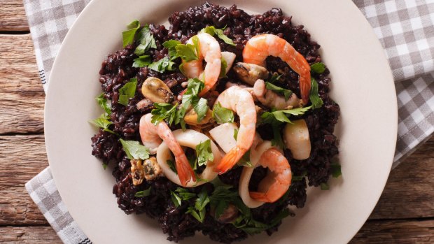 HFWNXP Black rice with shrimp, calamari, mussels and scallops on the plate closeup. Horizontal view from above satmay19eurofood 4/ Barcelona ? arroz negro ? black rice with cuttlefish at Carles Abellan?s La Barra in Barceloneta www.carlesabellan.com