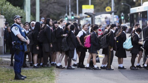 Police watch as pupils leave Sydney Girls High School.