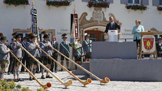 Alpenhorn players greet  Barack Obama and  Chancellor Angela Merkel.