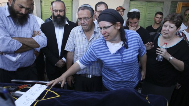 Rina Ariel touches the body of her slain  daughter Hallel, 13, during her funeral inside the Jewish West Bank settlement of Kiryat Arba.