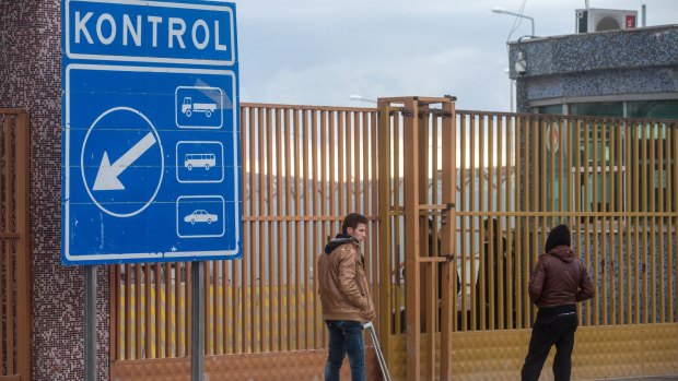 People wait outside a closed Turkish-Syrian border gate in Killis on Sunday.