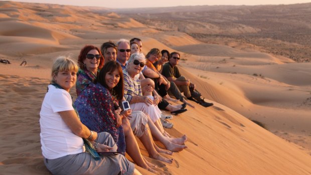 A Peregrine Adventures group enjoys the view from atop a dune.