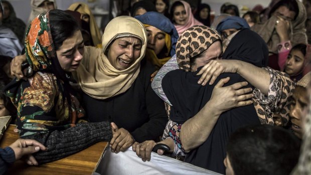 Female relatives mourn over the coffin of 15-year-old Mohammed Ali Khan after the school massacre in Peshawar.