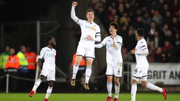 Giant leap towards safety: Alfie Mawson celebrates after scoring for Swansea.