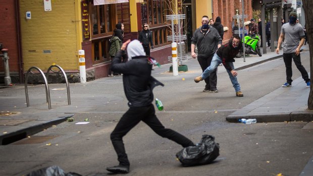 Members of the United Patriot Front throwing a bottle at a counter-protester.