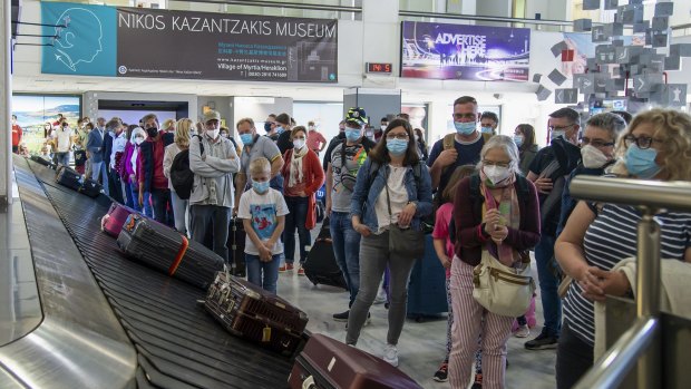 Passengers wait to pick their luggage at Nikos Kazantzakis International Airport in Heraklion, on the island of Crete, Greece. Greece has already lifted some restrictions on visitors.
