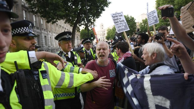 A scuffle breaks out as protesters attend a rally calling for justice for those affected by the Grenfell Tower fire outside Prime Minister Theresa May on Friday.