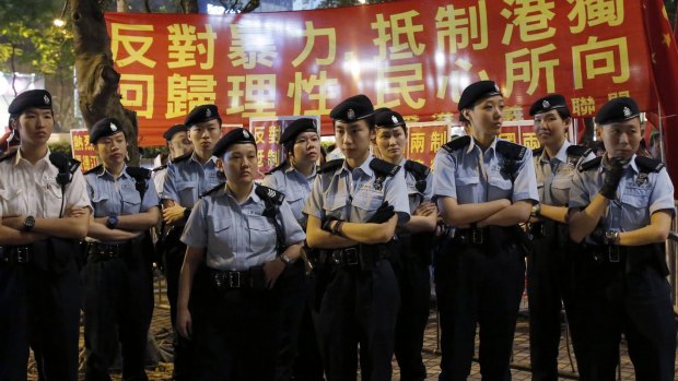 Policewomen stand guard in front of the banner of the pro-government protesters in Hong Kong on Wednesday.