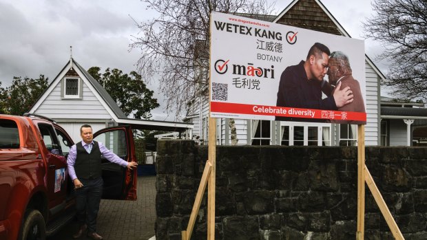 Wetex Kang arrives next to a campaign signs for the Maori Party in Auckland.
