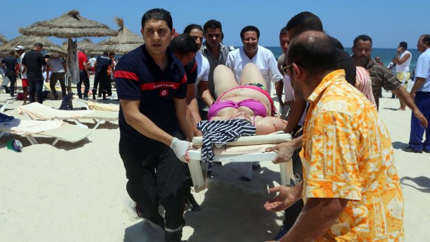 Tunisian medics carry a woman on a stretcher in the resort town of Sousse on Friday after the Islamic State terrorist attack.