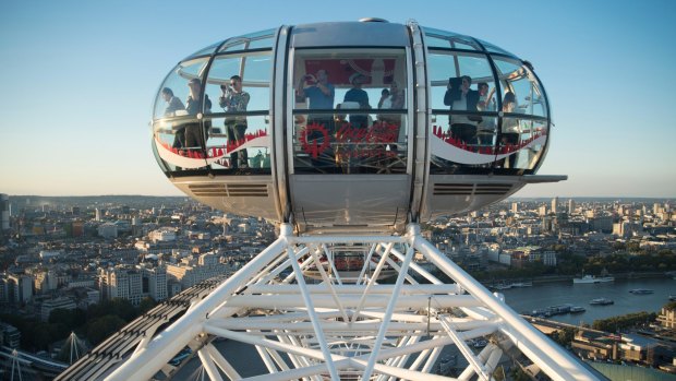 The London Eye ferris wheel overlooks the Thames River.