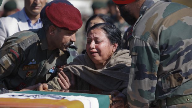The mother of an Indian Army captain, Tushar Mahajan, cries next the coffin of her son. The soldier died in a gun battle between Kashmiri rebels and Indian government forces.
