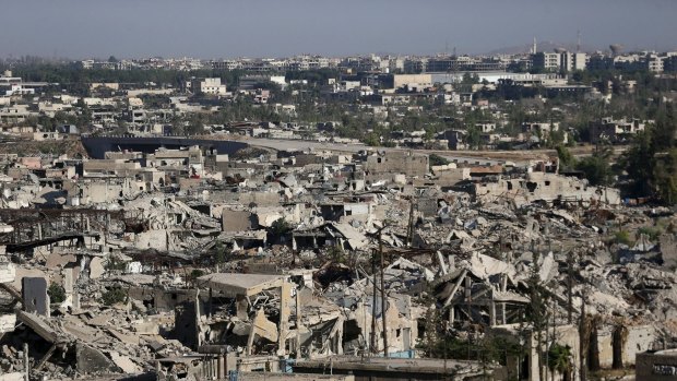 In this July 6 photo, bomb-damaged buildings in Jobar, a rebel-held suburb of Damascus, can be seen in the foreground. Damascus itself can be seen in the distance.  