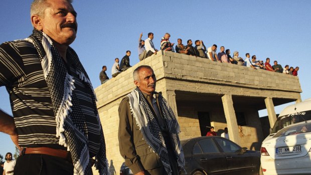 Turkish and Syrian Kurds gather on the Turkish side of its border with Syria to witness the battle for Kobane in October 2014.