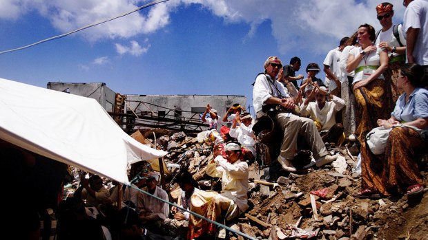 Family and friends of the victims of the 2002 Bali bombing sit amongst the rubble of the Sari club  during a Hindu  cleansing ceremony in November 2002.