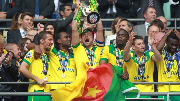 Going up: Norwich City's Russell Martin lifts the trophy.