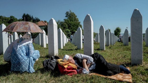 Mourners keep a vigil at a grave in the Srebrenica-Potocari Memorial Centre and Cemetery in Bosnia.