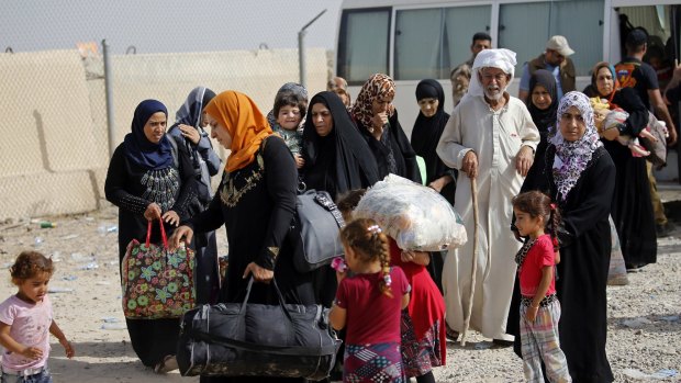 Displaced Iraqi families arrive to an Iraqi army camp during fighting between Iraqi security forces and IS on Saturday.