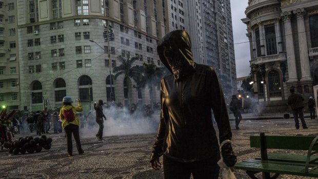 Protesters move away from tear gas during a general strike in Rio de Janeiro, Brazil, on Friday.