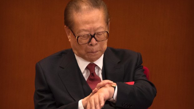Former Chinese president Jiang Zemin checks his wristwatch.