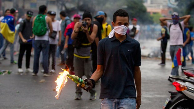 Demonstrator prepares to throw a molotov cocktail at police in Caracas.