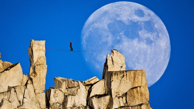 Dean Potter traversing a high line in Yosemite National Park as the moon rises. File